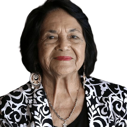 Elderly woman smiling, wearing a black and white patterned jacket and large earrings. This portrait highlights her confidence and presence.